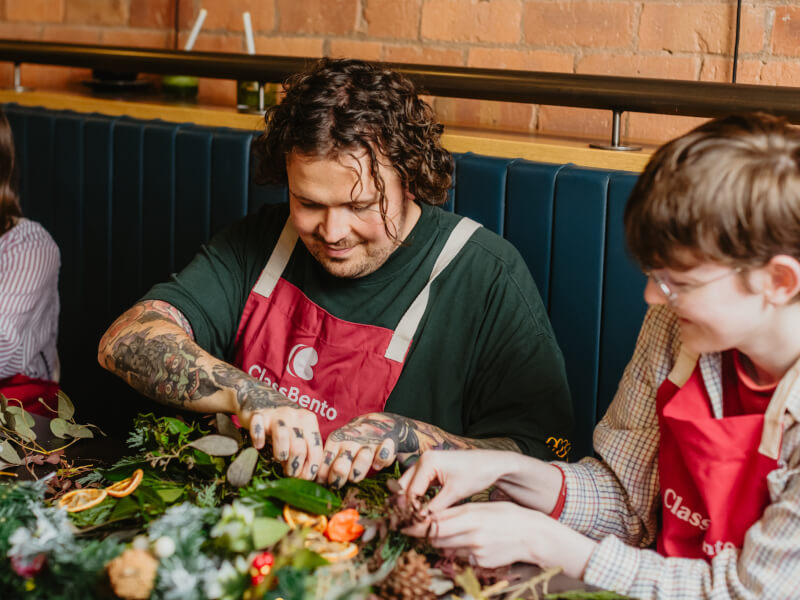 Man making a Christmas wreath at a craft class